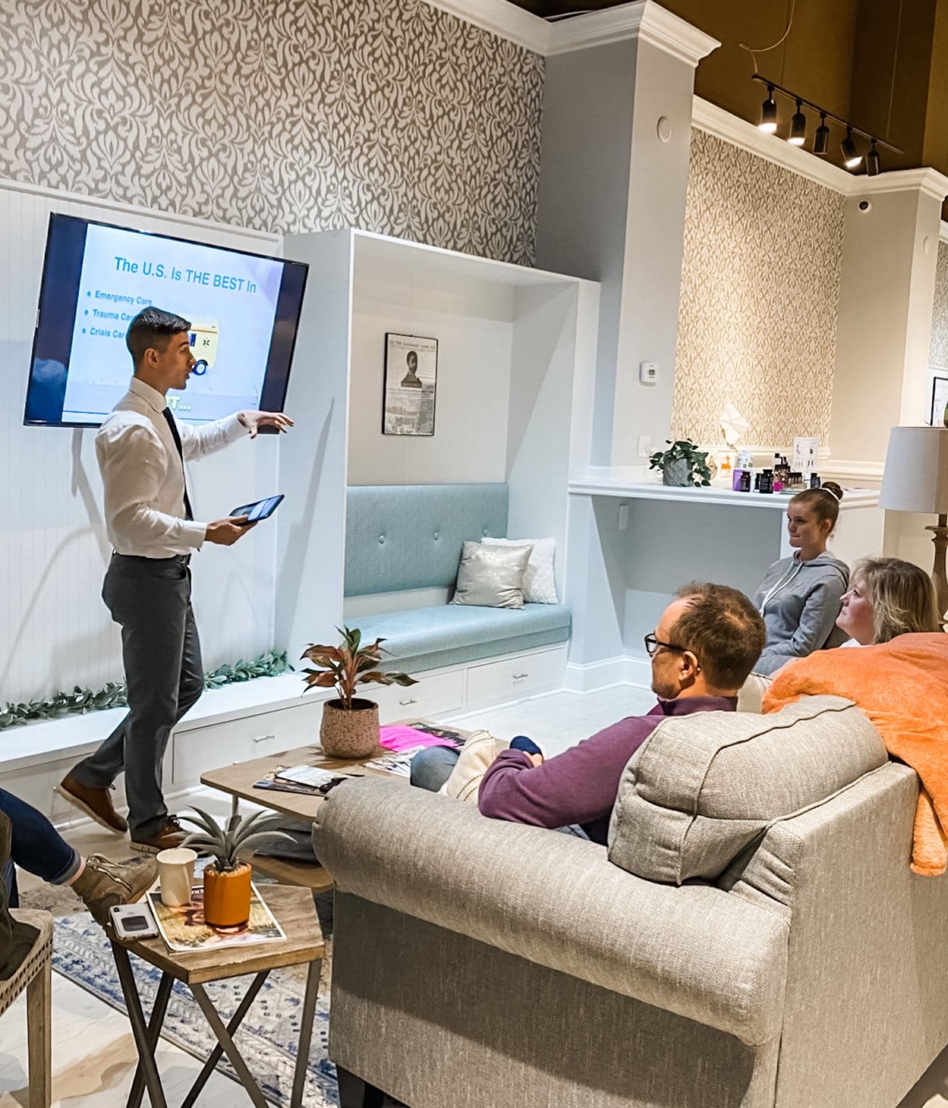 Dr. Tim Hartman pointing at a slide while guests watch from couches in the Limitless Chiropractic front room